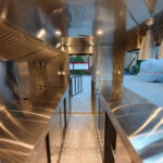 Interior of a custom BBQ food trailer with stainless steel counters and ventilation, built by Luxe Custom Co.