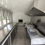 Custom pizza trailer interior with high-heat ovens and sleek counters by Luxe Custom Co, expert food trailer builders.
