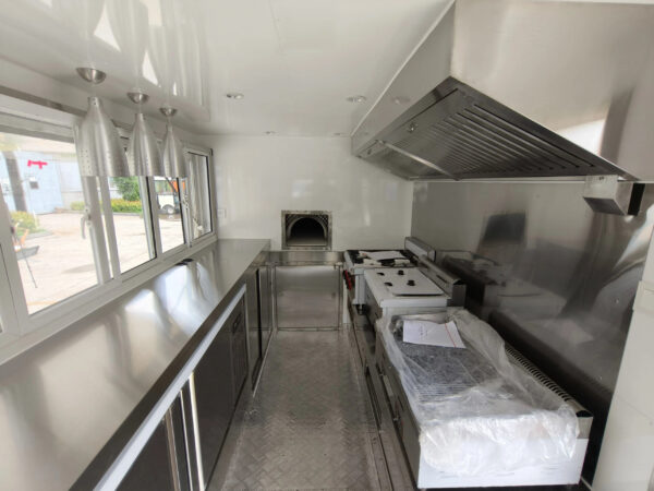 Custom pizza trailer interior with high-heat ovens and sleek counters by Luxe Custom Co, expert food trailer builders.