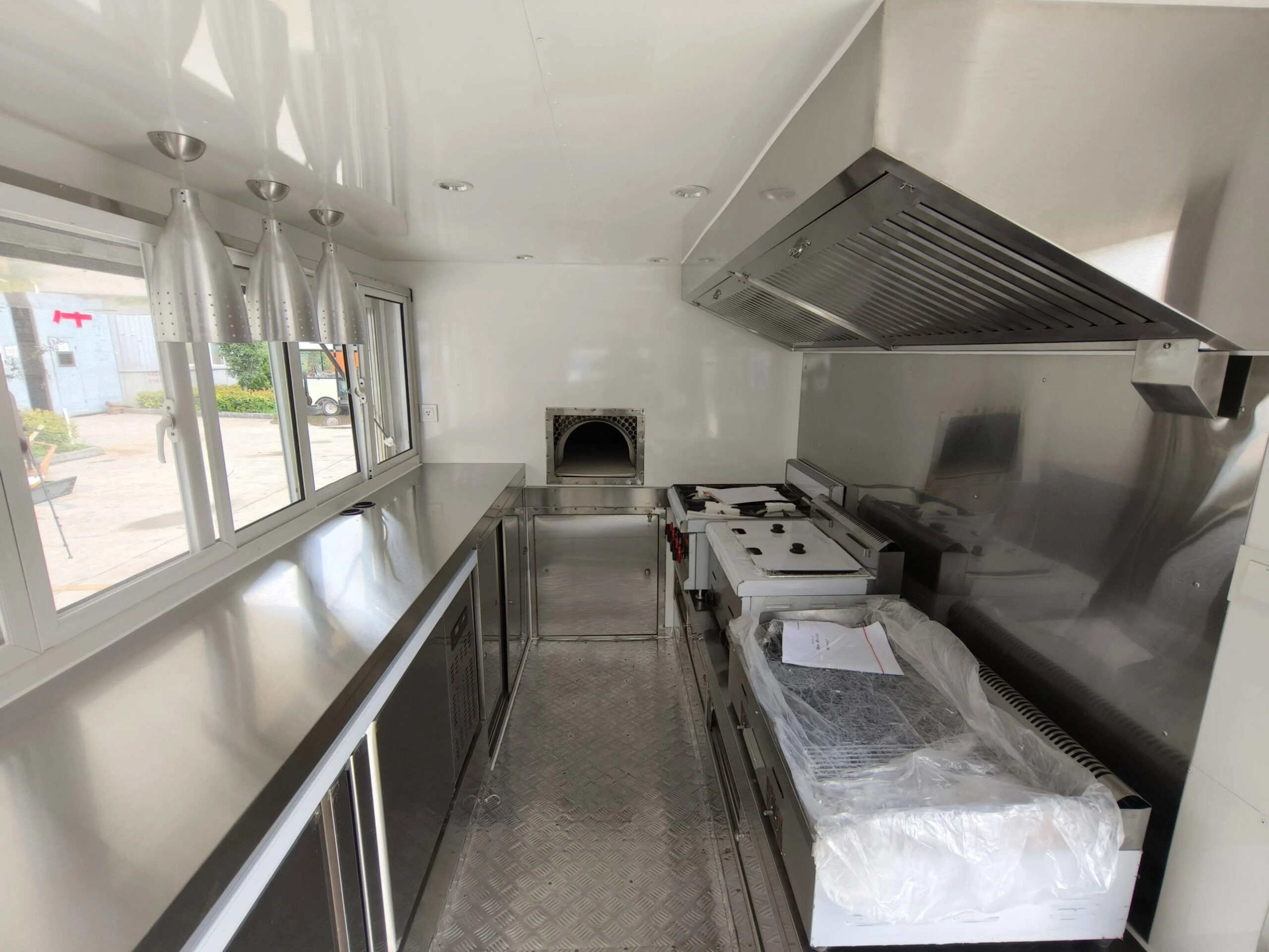 Custom pizza trailer interior with high-heat ovens and sleek counters by Luxe Custom Co, expert food trailer builders.