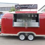 Side exterior of a 16ft pizza trailer with open serving window, crafted by Luxe Custom Co.