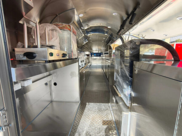 Interior of a custom food trailer with stainless steel counters and commercial blender for ice cream, crafted by Luxe Custom Co.