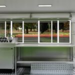 Interior of a mobile food trailer with stainless steel counters for ice cream prep, built by Luxe Custom Co.