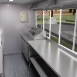Interior of a custom food trailer with stainless steel setup and ventilation for ice cream, crafted by Luxe Custom Co.